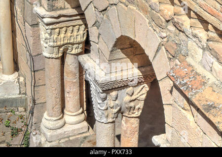 Arches arrondies romane avec chapiteaux sculptés en bas-reliefs de figures humaines, au cours d'une journée ensoleillée dans l'Alquezar Collegiate, Espagne Banque D'Images