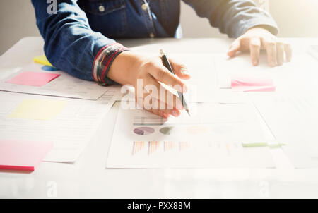 Femme de démarrage d'entreprise travailler avec les documents d'affaires sur la table du bureau graphique avec schéma financier. Banque D'Images