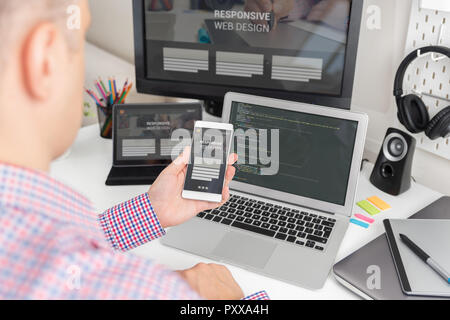 Designer de travailler sur projet responsive web design. Développeur Web et programmeur travaillant dans office avec les appareils modernes sur 24 Banque D'Images