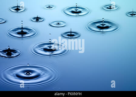 Très belle et grande photo de la pluie. Les gouttes de pluie tombent sur la surface de l'eau lisse. Banque D'Images