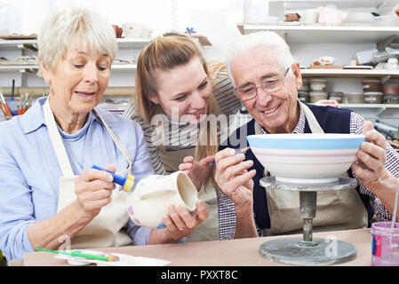 Senior Couple with Teacher In Pottery Class Banque D'Images