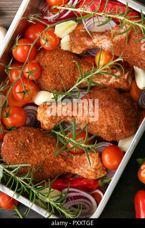 Pilons de poulet cru mariné préparer les jambes pour cuire au four ou grill et barbecue Banque D'Images