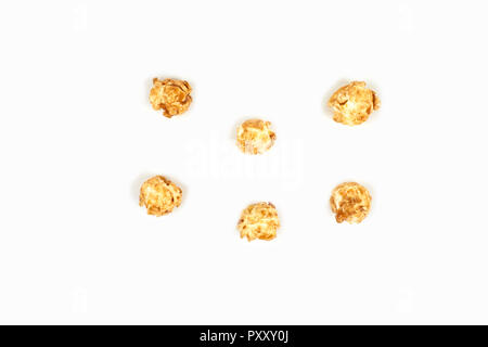 Maïs soufflé au caramel sur fond blanc. Banque D'Images