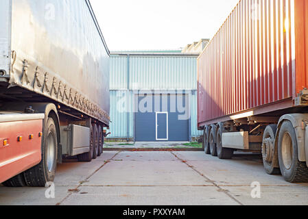 Deux camions, debout près de la porte de garage bleu Banque D'Images