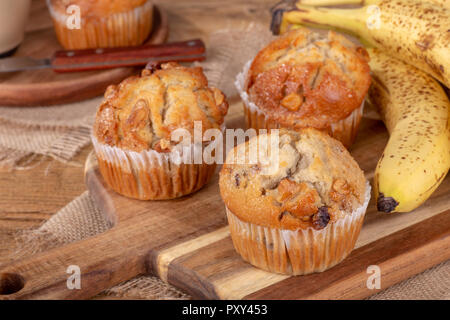 Muffins Bananes et noix et les bananes sur une planche en bois Banque D'Images