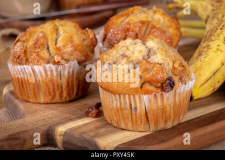 Libre de bananes et noix muffins aux bananes en arrière-plan sur une planche en bois Banque D'Images