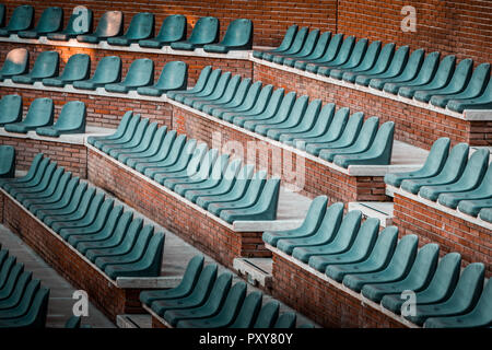 Gratuitement sur plusieurs rangées de sièges non réclamés. Coucher du soleil photo dans public vide de concerts et l'amphithéâtre. Brique rouge et blanc travertin structure. Banque D'Images