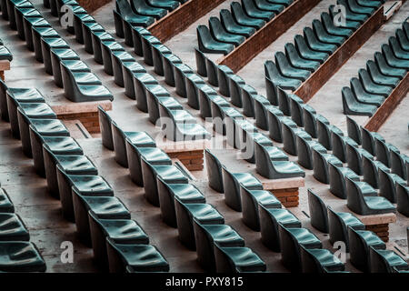 Gratuitement sur plusieurs rangées de sièges non réclamés. Coucher du soleil photo dans public vide de concerts et l'amphithéâtre. Brique rouge et blanc travertin structure. Banque D'Images