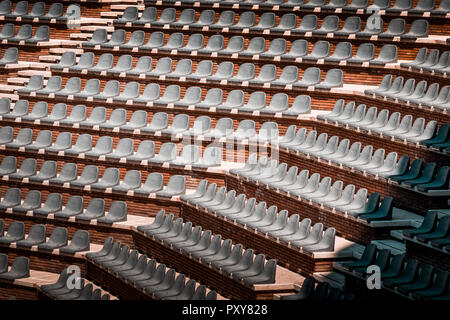 Gratuitement sur plusieurs rangées de sièges non réclamés. Coucher du soleil photo dans public vide de concerts et l'amphithéâtre. Brique rouge et blanc travertin structure. Banque D'Images