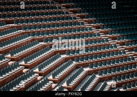 Gratuitement sur plusieurs rangées de sièges non réclamés. Coucher du soleil photo dans public vide de concerts et l'amphithéâtre. Brique rouge et blanc travertin structure. Banque D'Images