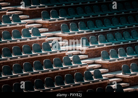 Gratuitement sur plusieurs rangées de sièges non réclamés. Coucher du soleil photo dans public vide de concerts et l'amphithéâtre. Brique rouge et blanc travertin structure. Banque D'Images