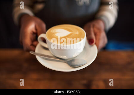 Barista tenant une tasse de Cappuccino faite avec amour Banque D'Images