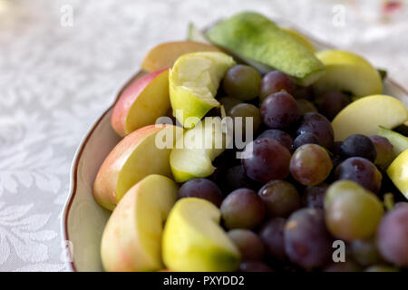 Assiette de raisins et les tranches de pommes et poires Banque D'Images