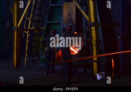 Metal forge, l'établissement boutique. Marteau hydraulique façonne le red-hot billet. La production de pièces de haute technologie. Formes et de modèle pour l'artiste blacksmit Banque D'Images