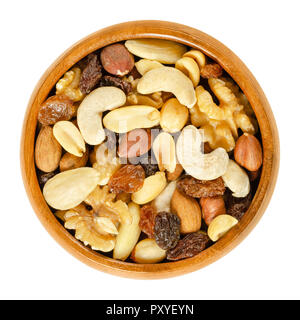 En étudiant l'alimentation bol en bois. Élève du fourrage. Snack-mélange d'amandes séchées, noix de cajou, arachides, noix, noisettes et raisins secs. Mélange de traînée. Banque D'Images