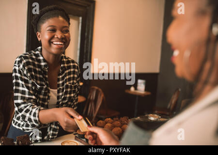 Femme de payer pour un café avec sa carte bancaire Banque D'Images
