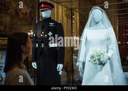 Windsor, Royaume-Uni. 25 octobre, 2018. Sous EMBARGO JUSQU'À LA PUBLICATION DE L'image 00:01 CEST, LE VENDREDI 26 OCTOBRE. Curator Caroline de Guitaut pose à côté de la duchesse de la robe de mariée de Sussex, créé par le designer britannique Clare Waight Keller, directrice artistique lors de l'historique maison de mode française Givenchy, et le duc de Sussex est uniforme frockcoat de la Household Cavalry, qui sera exposé au château de Windsor du 26 octobre 2018 au 6 janvier 2019 dans le cadre d'une exposition spéciale intitulée "Un mariage royal : le duc et la duchesse de Kent'. Credit : Mark Kerrison/Alamy Live News Banque D'Images