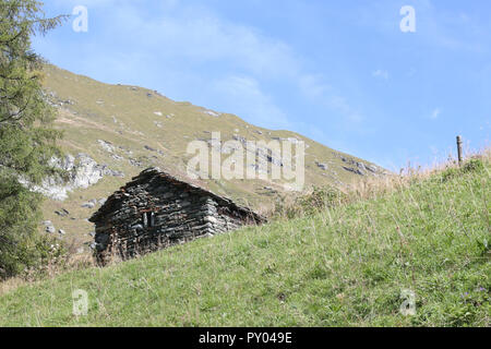 Une cabane en pierre dans la ville de Walser, Pianmisura avec de hautes montagnes, forêts de pins et de prairies, en été, dans le Val d'Otro vallée, Alpes, Italie Banque D'Images