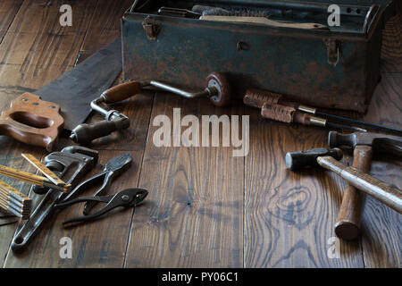 Outils anciens et grungy boîte à outils sur la surface en bois sombre. Banque D'Images