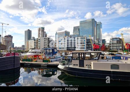 Dans les péniches amarrées bassin avec le Blackwall gratte-ciel modernes de Canary Wharf en arrière-plan, les Docklands de Londres Angleterre Royaume-uni Banque D'Images