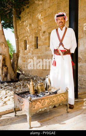 Portrait d'un homme portant des vêtements traditionnels arabes par permanent thé traditionnel sur table à thé gravée, gouvernorat de Madaba, Jordanie Banque D'Images