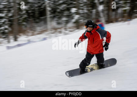 Snowboarder dans winter park descend la colline très rapidement dans une station de ski Banque D'Images