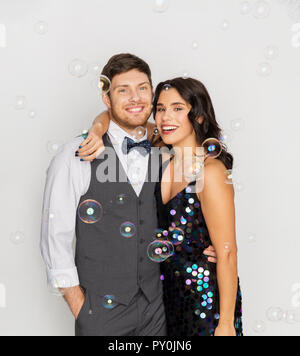 Heureux couple hugging in bulles de savon at party Banque D'Images