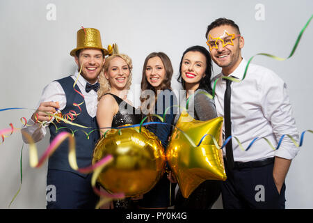 Amis avec partie d'accessoires et de confettis de rire Banque D'Images