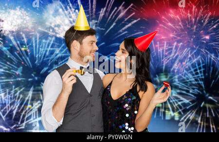 Couple heureux avec party blowers s'amusant Banque D'Images