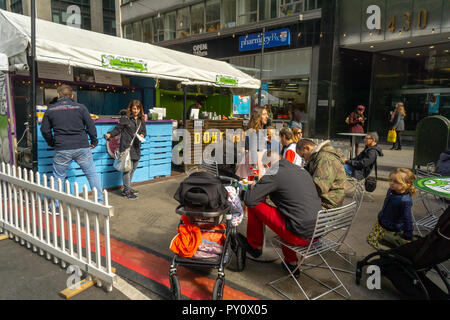 Les visiteurs apprécient les offrandes à l'UrbanSpace Garment District marché plein air sur Broadway à New York le samedi 20 octobre 2018. La célèbre foire de l'alimentation temporaire, sur Broadway dans le quartier de Garment, apporte toute une gamme de restaurants offrant un coin repas extérieur attire l'expérience des employés de bureau qui ont faim, les consommateurs et les touristes. UrbanSpace gère un certain nombre de pop-ups dans la ville y compris Madison Sq. Mange, morsures et Broadway est surtout connu de la longue maison de Union Square marché..(Â© Richard B. Levine) Banque D'Images