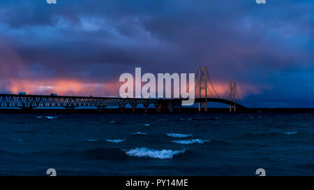 Coucher de soleil avec des nuages orageux s'allumer le Mackinac Bridge enjambant le détroit de Mackinac entre les péninsules supérieure et inférieure du Michigan, USA. Banque D'Images