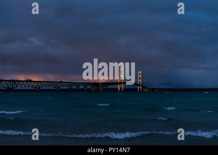 Coucher de soleil avec des nuages orageux s'allumer le Mackinac Bridge enjambant le détroit de Mackinac entre les péninsules supérieure et inférieure du Michigan, USA. Banque D'Images