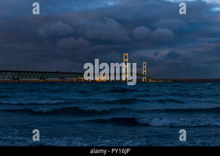 Coucher de soleil avec des nuages orageux s'allumer le Mackinac Bridge enjambant le détroit de Mackinac entre les péninsules supérieure et inférieure du Michigan, USA. Banque D'Images