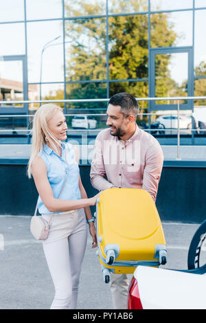 Smiling couple marié mettre une assurance en voiture sur parking Banque D'Images