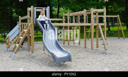 Petite fille sur une aire de jeux. Enfant jouant à l'extérieur en été. Les enfants jouent sur la cour de l'école. Banque D'Images