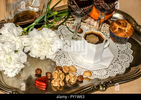 Les œillets,Black,café vieux verres cristal avec une bouteille de liqueur de noix,et une orange, perles, perles de coquillages sur un plateau d'argent Nickel Banque D'Images