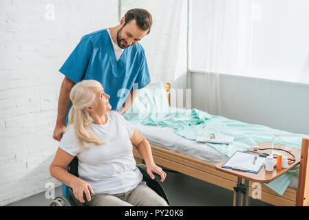 Portrait of smiling male nurse senior woman in wheelchair Banque D'Images