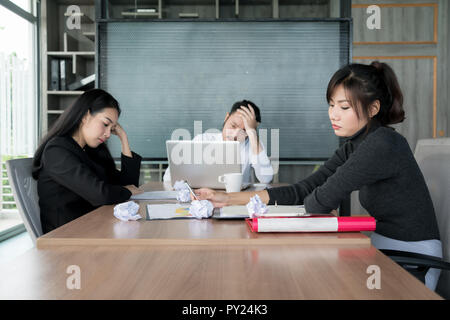 Groupe de malheureux affaires asiatiques en costume décontracté assis dans la salle de réunion d'affaires et à la souche. Banque D'Images