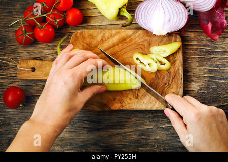 Close-up of woman mains couper des légumes sur le plateau, vue du dessus Banque D'Images