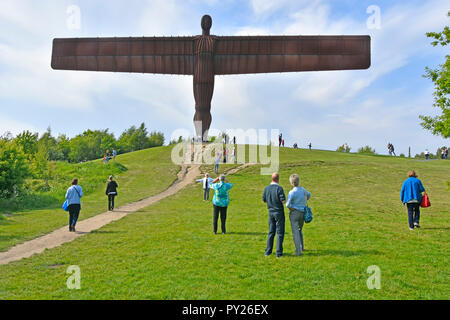 Rusty à la célèbre sculpture en acier Corten Ange du Nord par Antony Gormley personnes posant les touristes et prendre des photos Gateshead England UK Banque D'Images