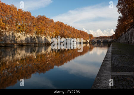 Une vue le long du Tibre à Rome le long d'une journée d'automne. Les arbres le long du bord de la rivière sont de belles couleurs d'automne et se reflètent parfaitement Banque D'Images