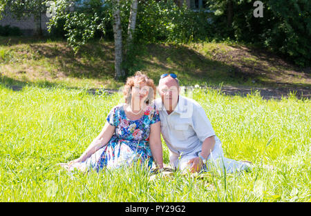 L'homme et la femme s'asseoir sur l'herbe. Banque D'Images