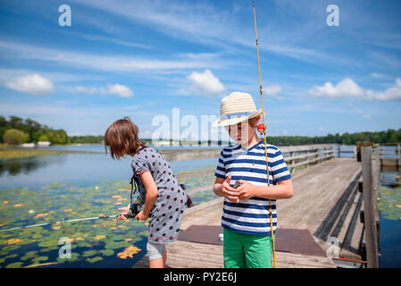 Deux enfants sur un quai de pêche en été, United States Banque D'Images