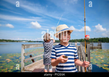 Deux enfants sur un quai de pêche en été, United States Banque D'Images