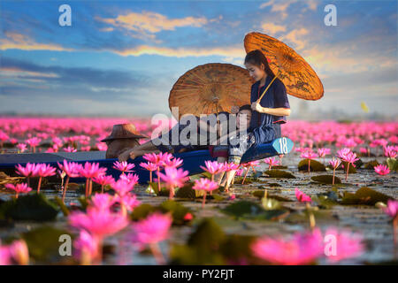 Deux femmes assises sur un bateau dans une fleur de lotus lake, Thaïlande Banque D'Images