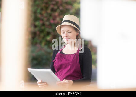 Portrait d'une serveuse dans un restaurant en plein air holding spéciaux Banque D'Images