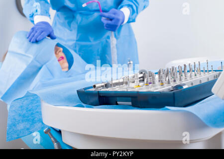 Dentiste en uniforme bleu d'effectuer la chirurgie d'implant dentaire Banque D'Images