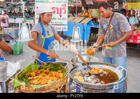 La ville de Phuket, Thaïlande - 4 Avril 2010 : la cuisson des croquettes de poisson au marché du weekend. Le marché est ouvert tous les samedi et dimanche. Banque D'Images