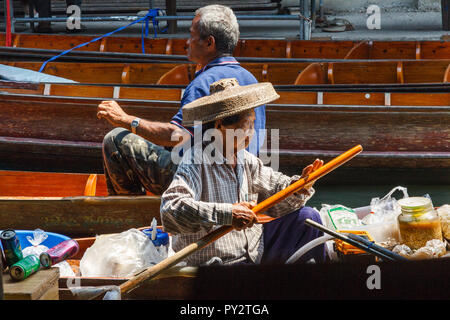 Damnoen Saduak, Thaïlande - 4 mars 2017 : une femme paddles son bateau au marché flottant. De nombreux touristes visitent le marché. Banque D'Images