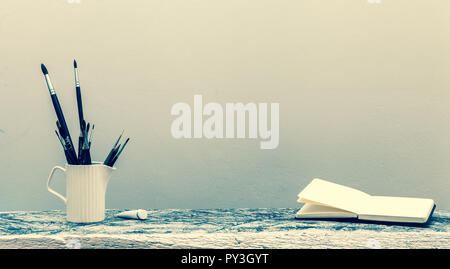 Un verre avec glands artistique sur la table et un bloc-notes pour dessiner. art filtre. L'arrière-plan Banque D'Images